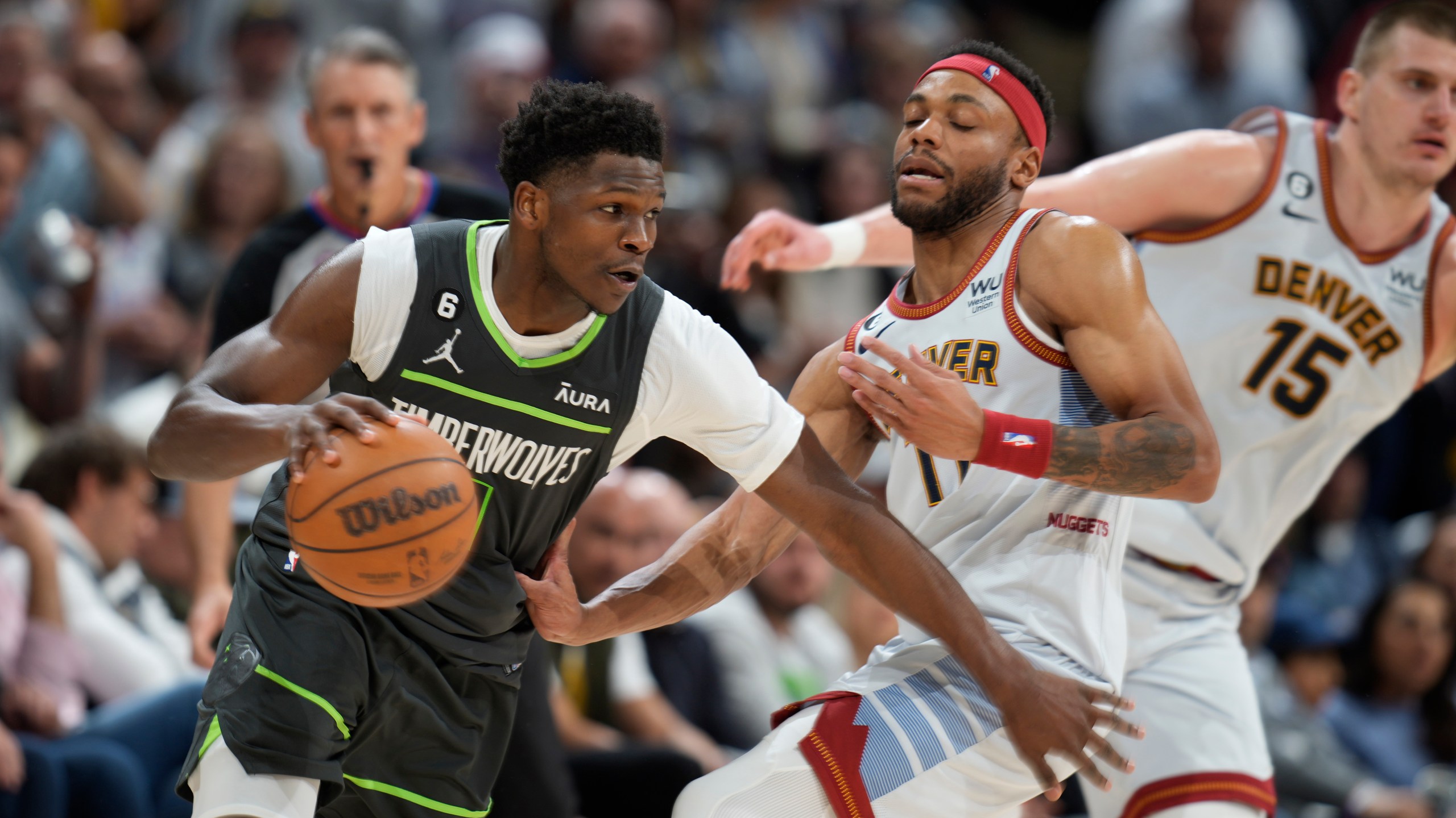 Minnesota Timberwolves guard Anthony Edwards, left, drives against Denver Nuggets forward Bruce Brown and center Nikola Jokic, right