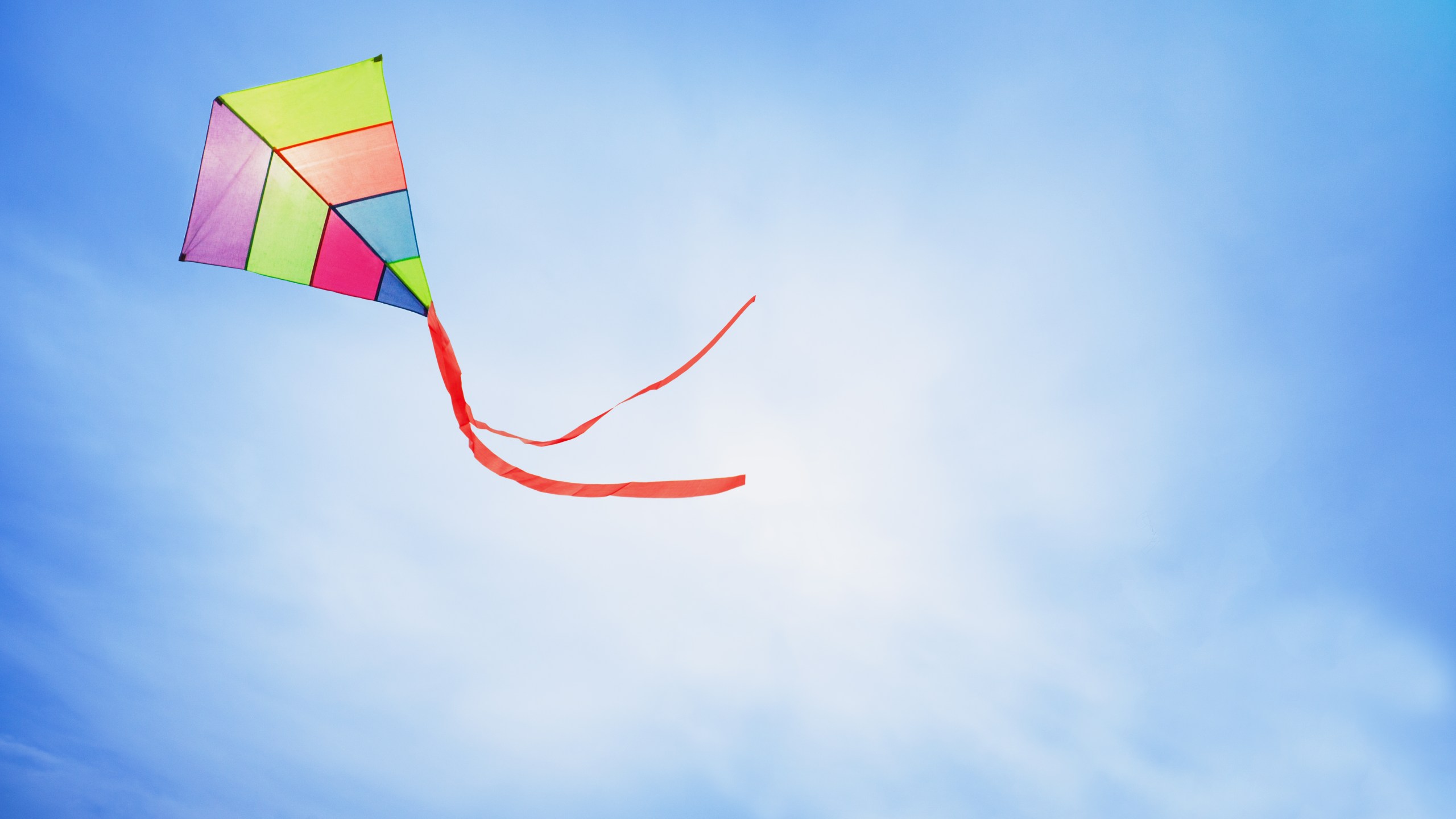 colorful kite flying with waving red bow