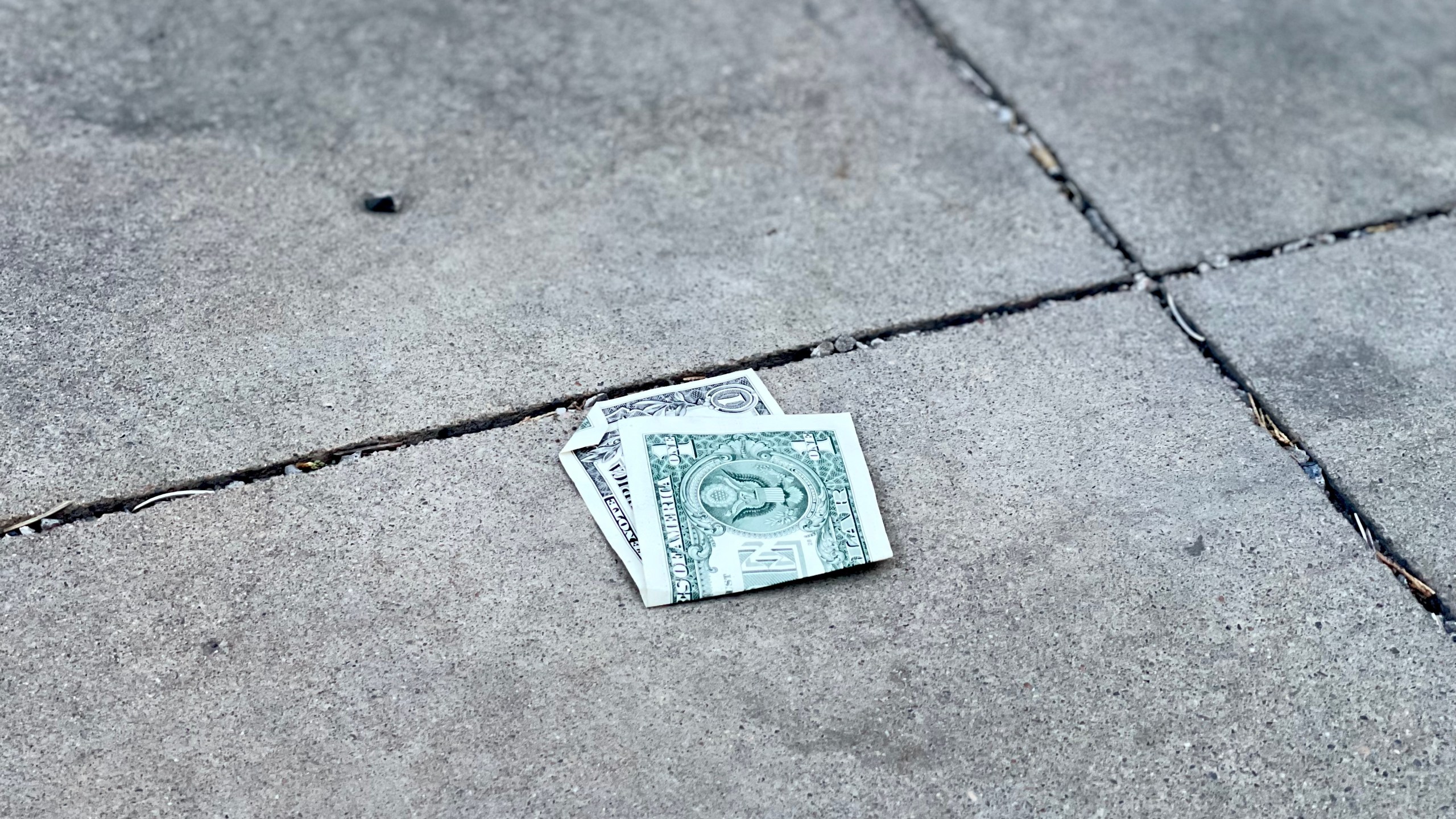 Dollar bill folded on ground