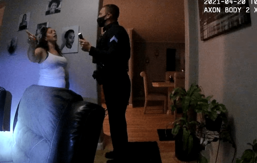 Screen grab of Denver Police Department body camera video showing a woman and an officer speaking inside a home