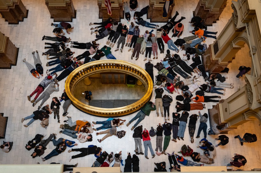 Aerial shot of dozens of teens lying on the ground of the Colorado Capitol