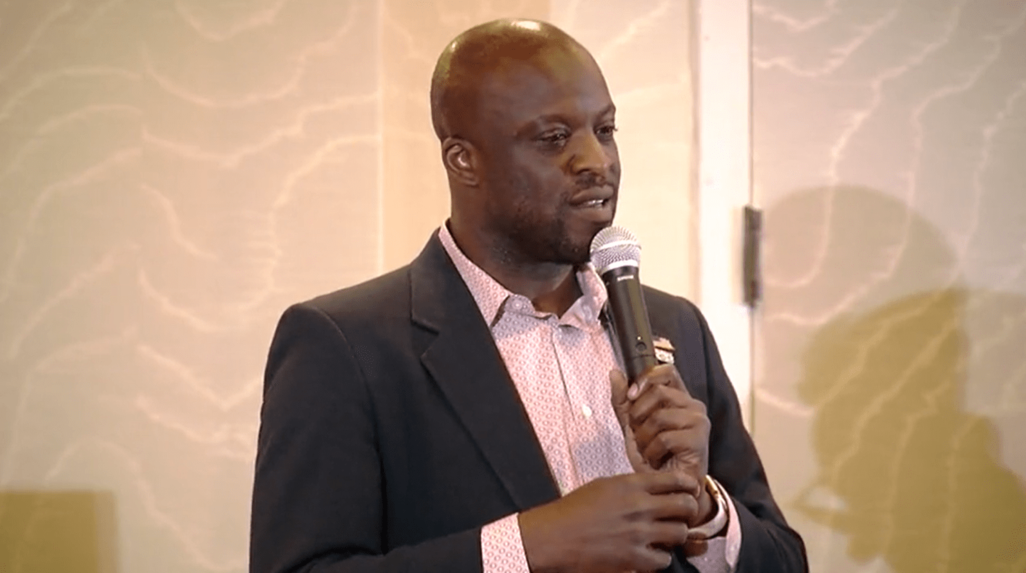 Yemi Mobolade speaks into a microphone during a forum