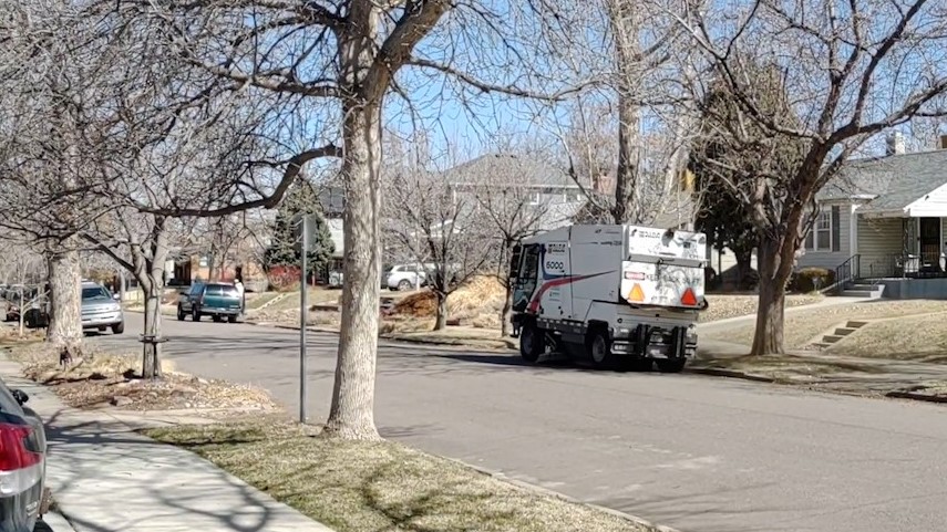 A street sweepers rolls down a block in South Denver