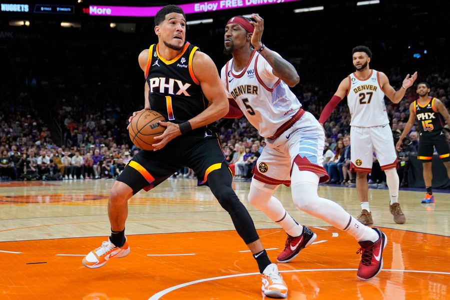 Phoenix Suns guard Devin Booker (1) looks to shoot as Denver Nuggets guard Kentavious Caldwell-Pope (5) defends during the first half of Game 3 of an NBA basketball Western Conference semifinal game, Friday, May 5, 2023, in Phoenix. (AP Photo/Matt York)