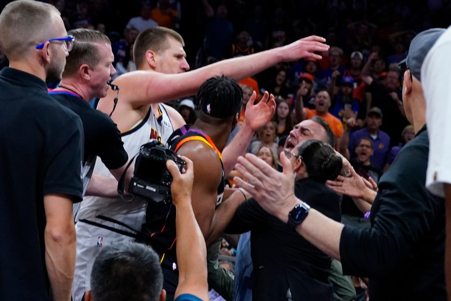 Denver Nuggets center Nikola Jokic get into an altercation in the stands during the first half of Game 4 of an NBA basketball Western Conference semifinal game against the Phoenix Suns, Sunday, May 7, 2023, in Phoenix. (AP Photo/Matt York)