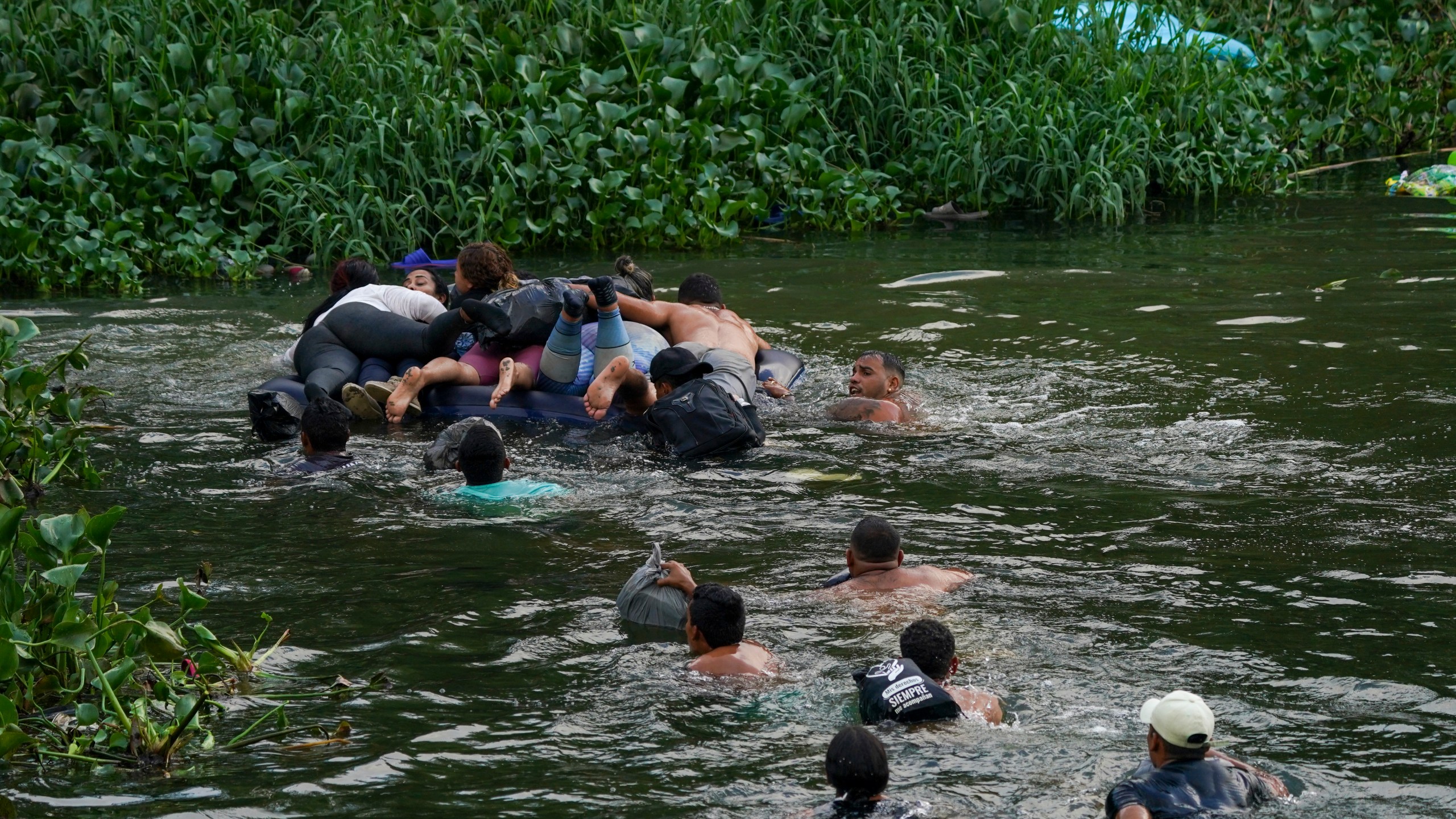 Migrants cross the Rio Bravo into the United States from Matamoros, Mexico