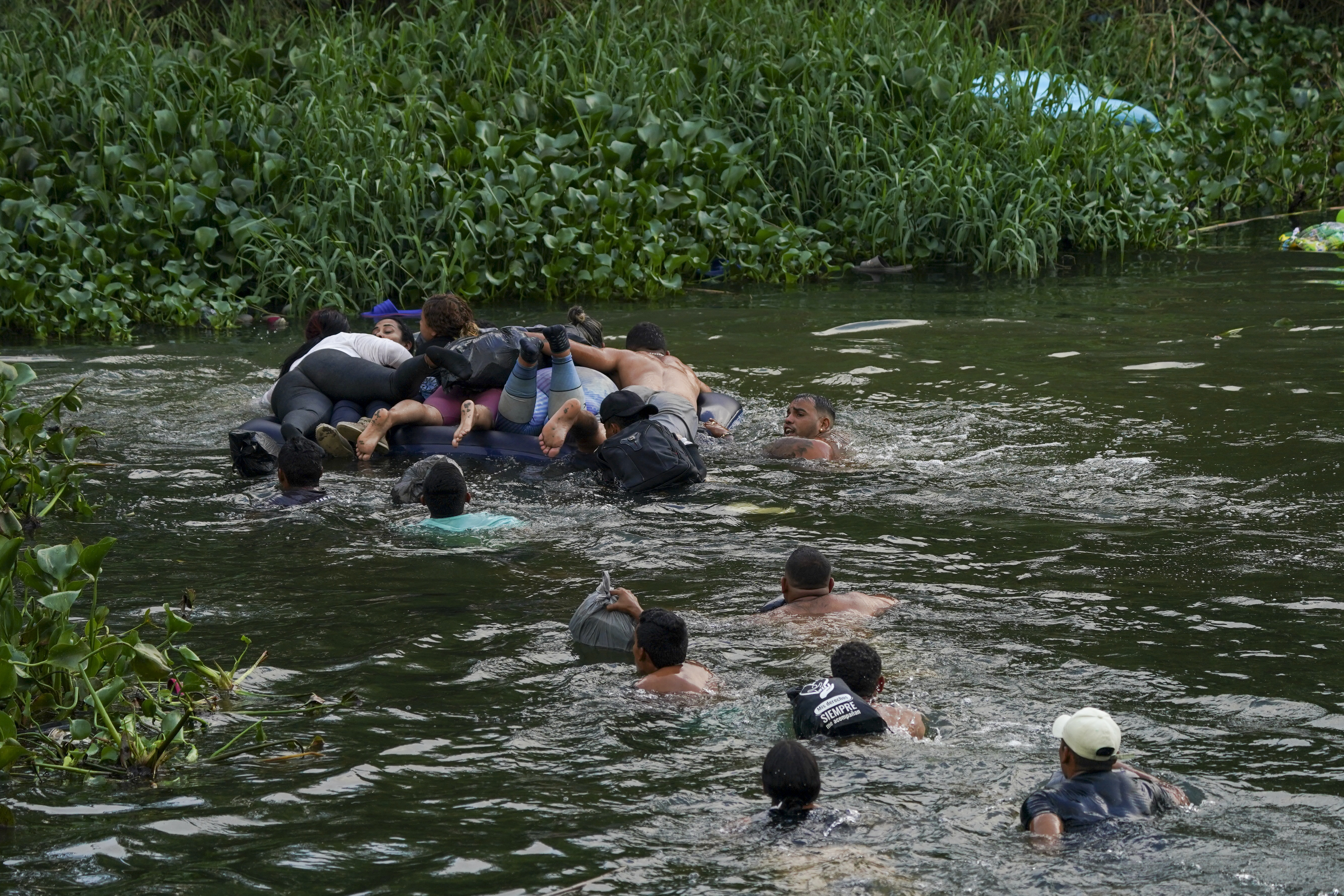 Migrants cross the Rio Bravo into the United States from Matamoros, Mexico