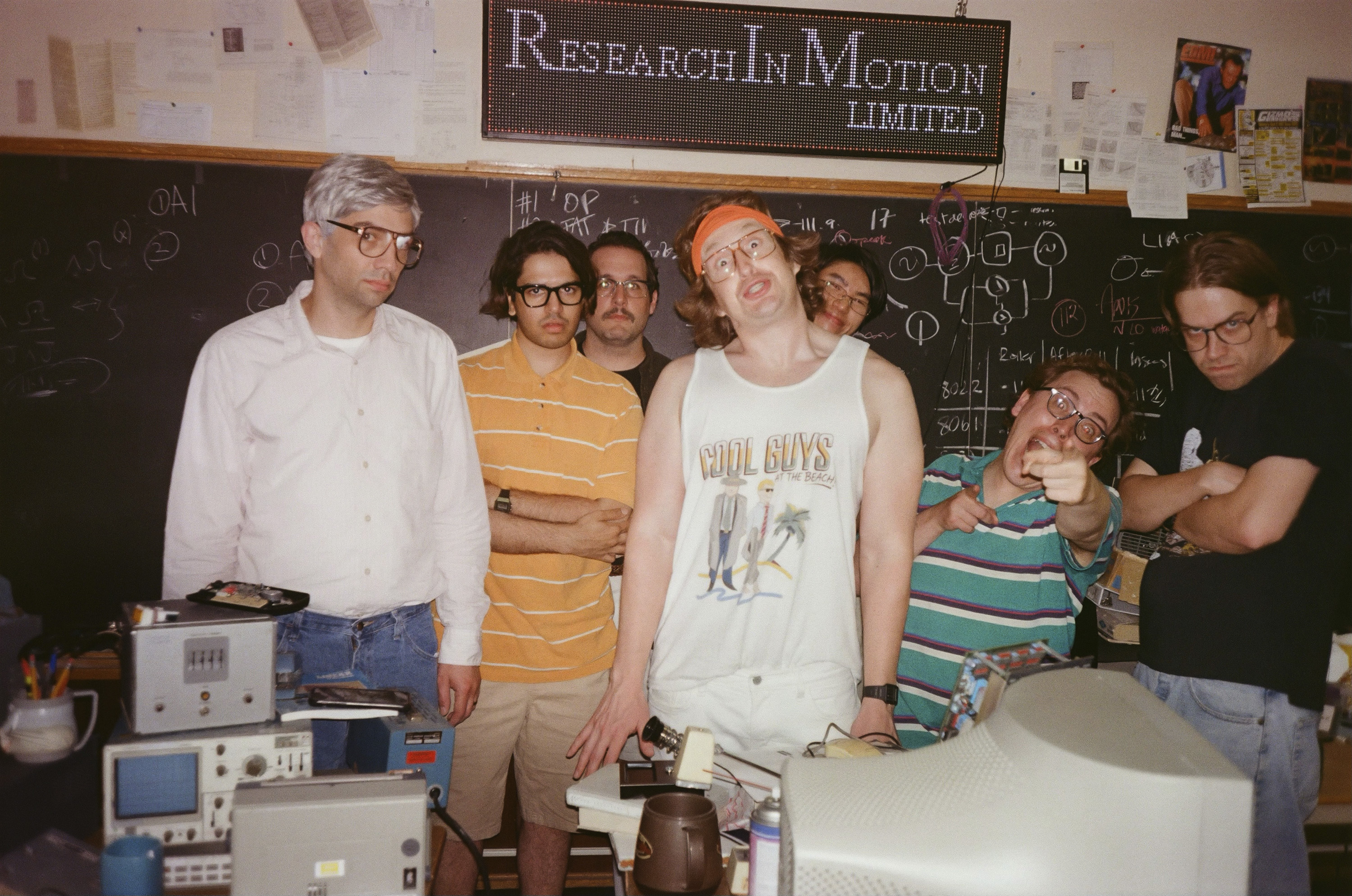 This image released by IFC Films shows Jay Baruchel, left, and actor-director Matt Johnson, center, with cast members on the set of "BlackBerry." (IFC Films via AP)