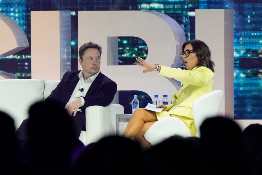 FILE - Twitter CEO Elon Musk, center, speaks with Linda Yaccarino, chairman of global advertising and partnerships for NBC, at the POSSIBLE marketing conference, Tuesday, April 18, 2023, in Miami Beach, Fla. Musk announced Friday, May 12, 2023, that he's hiring Yaccarino to be the new CEO of San Francisco-based Twitter, which is now called X Corp. (AP Photo/Rebecca Blackwell, File)