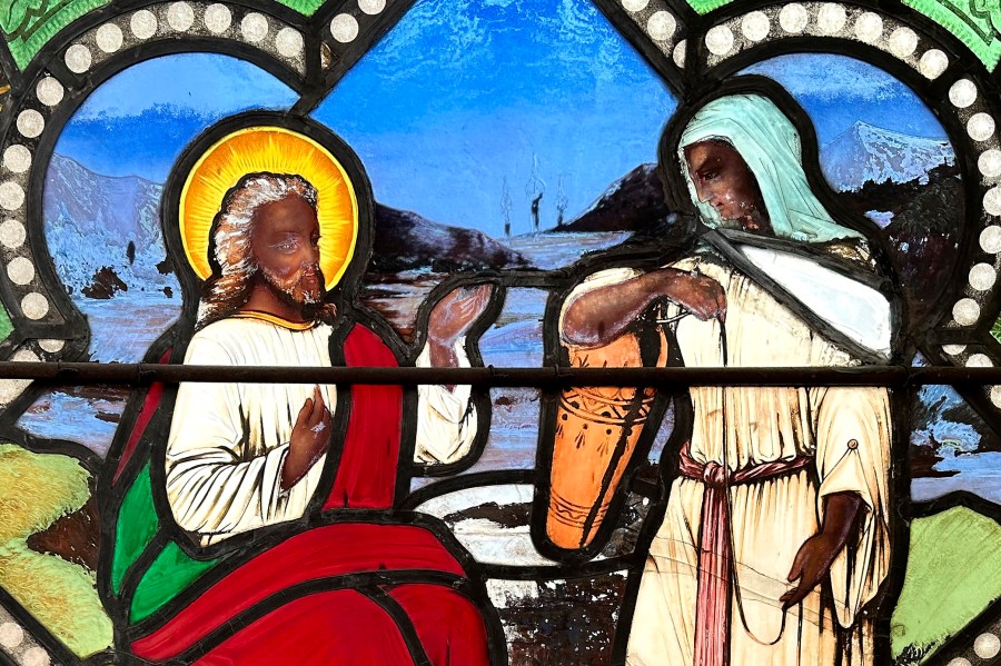 A detail of a nearly 150-year-old stained-glass window depicts Christ speaking to a Samaritan woman, in the now-closed St. Mark's Episcopal church, Monday, May 1, 2023, in Warren, R.I. The nearly 150-year-old stained-glass window from the Rhode Island church that depicts Christ and three New Testament women with dark skin has stirred up questions about race and the place of women in both biblical and 19th century society. (AP Photo/Mark Pratt)