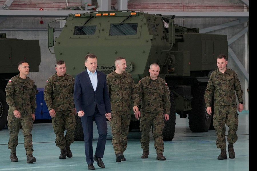 Poland's Defense Minister Mariusz Blaszczak, center, walks during ceremony after receiving its first shipment of U.S.-made HIMARS rocket launchers, at an air base in Warsaw, Poland, on Monday, 15 May 2023. Poland has received its first shipment of U.S.-made HIMARS rocket launchers, part of an upgrade of its defenses amid security concerns due to the war in neighboring Ukraine. (AP Photo/Czarek Sokolowski)