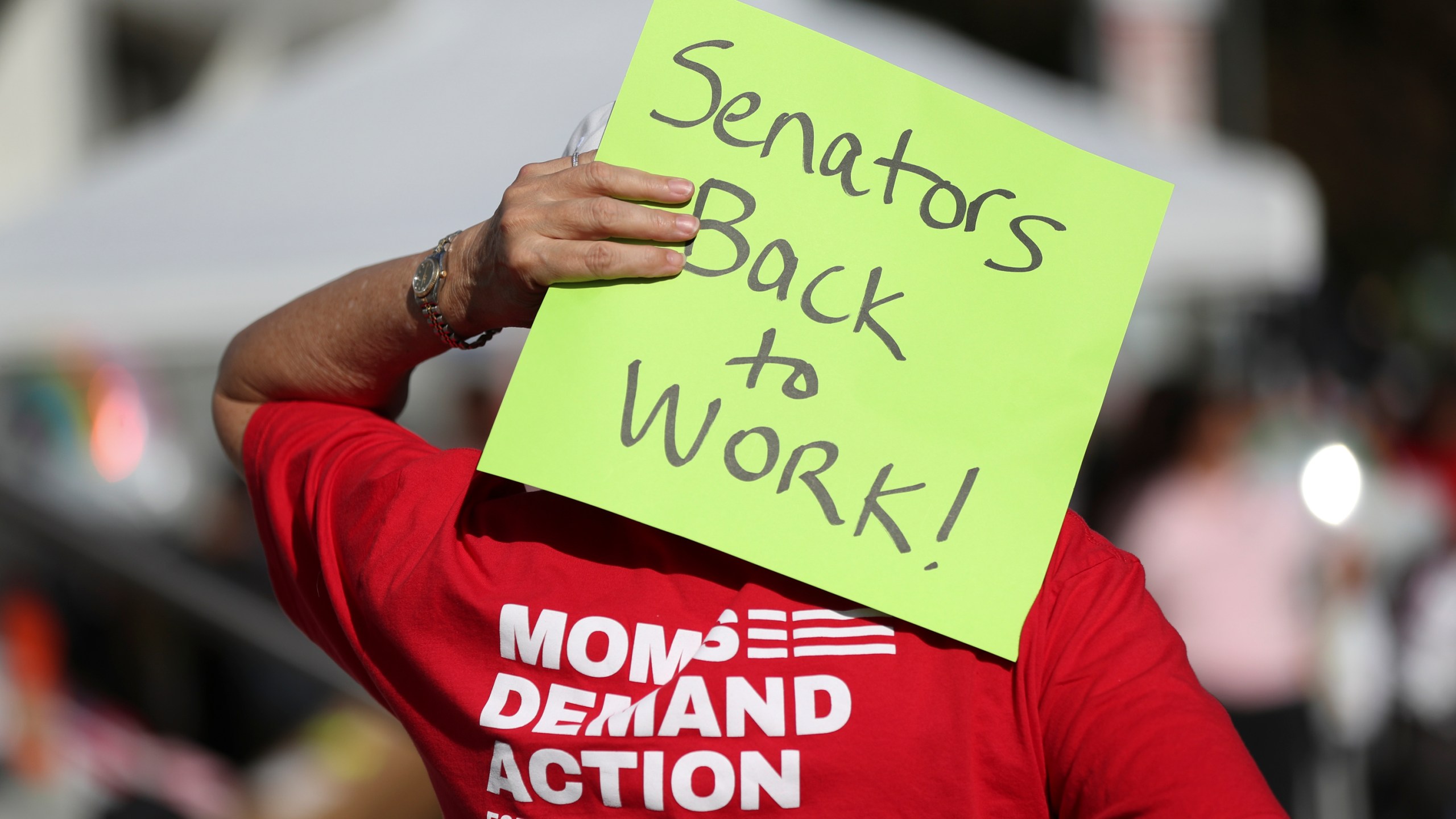 FILE - An attendee holds a sign behind their head during a rally calling for an end to the Senate Republican walkout at the Oregon State Capitol in Salem, Ore., May 11, 2023. Republicans and an independent senator in the Oregon Senate stretched a walkout Monday, May 15, to 10 days, triggering a new constitutional provision that prohibits lawmakers with 10 or more unexcused absences from being reelected. The walkout that began May 3 has stalled action on hundreds of bills, including on gun control, gender-affirming care and abortion rights, as a deadline threatened to disqualify them from being reelected. (AP Photo/Amanda Loman, File)