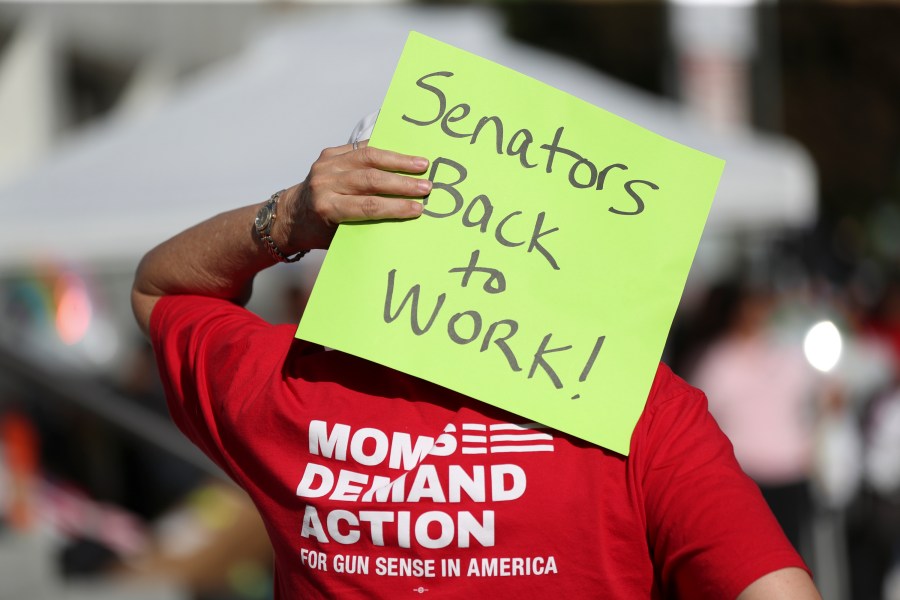 FILE - An attendee holds a sign behind their head during a rally calling for an end to the Senate Republican walkout at the Oregon State Capitol in Salem, Ore., May 11, 2023. Republicans and an independent senator in the Oregon Senate stretched a walkout Monday, May 15, to 10 days, triggering a new constitutional provision that prohibits lawmakers with 10 or more unexcused absences from being reelected. The walkout that began May 3 has stalled action on hundreds of bills, including on gun control, gender-affirming care and abortion rights, as a deadline threatened to disqualify them from being reelected. (AP Photo/Amanda Loman, File)