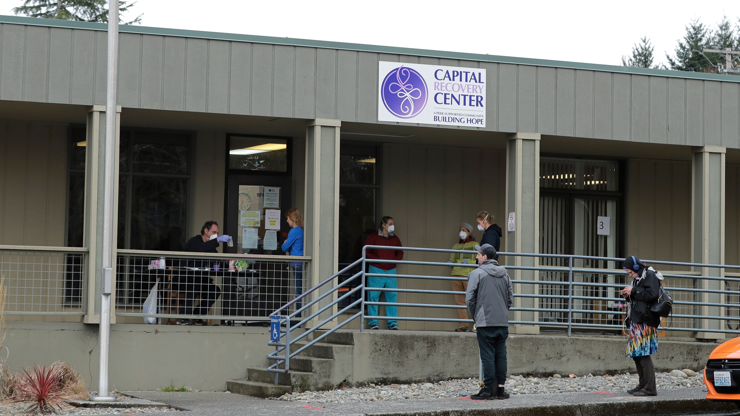 FILE - Patients line up to pick up medication for opioid addiction at a clinic in Olympia, Wash., on March 27, 2020. (AP Photo/Ted S. Warren, File)