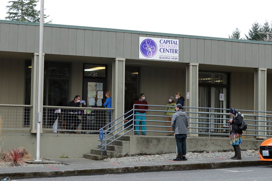 FILE - Patients line up to pick up medication for opioid addiction at a clinic in Olympia, Wash., on March 27, 2020. (AP Photo/Ted S. Warren, File)