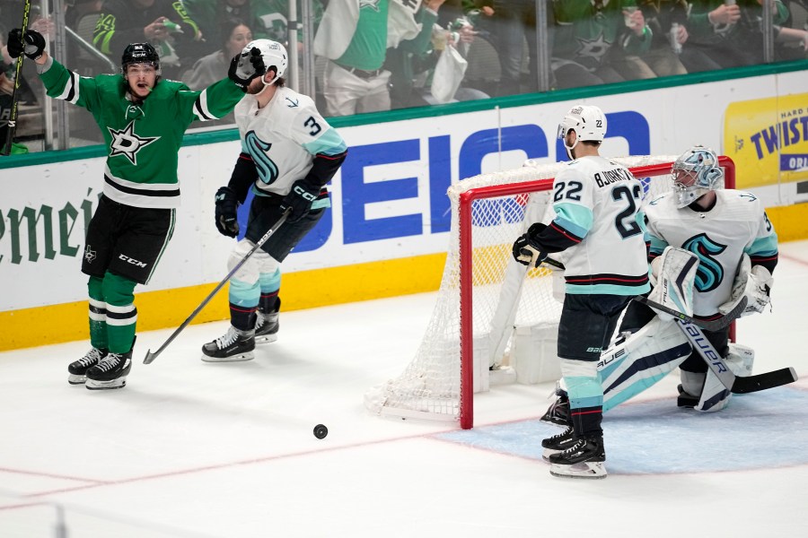 Dallas Stars center Wyatt Johnston, left, celebrates after scoring as Seattle Kraken's Will Borgen (3), Oliver Bjorkstrand (22) and goaltender Philipp Grubauer, right, look on in the third period of Game 7 of an NHL hockey Stanley Cup second-round playoff series, Monday, May 15, 2023, in Dallas. (AP Photo/Tony Gutierrez)