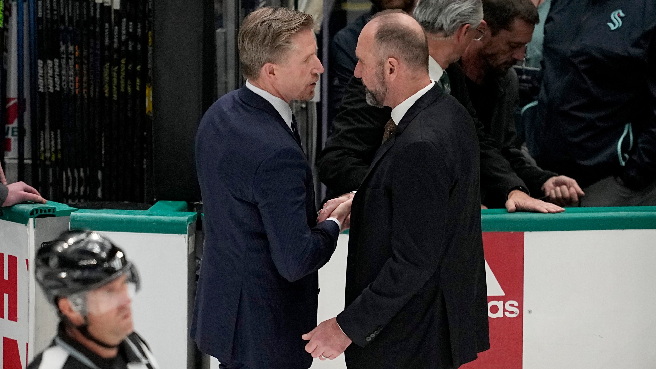 Seattle Kraken head coach Dave Hakstol, left, and Dallas Stars head coach Peter DeBoer, right, shake hands after Game 7 of an NHL hockey Stanley Cup second-round playoff series, Monday, May 15, 2023, in Dallas. (AP Photo/Tony Gutierrez)