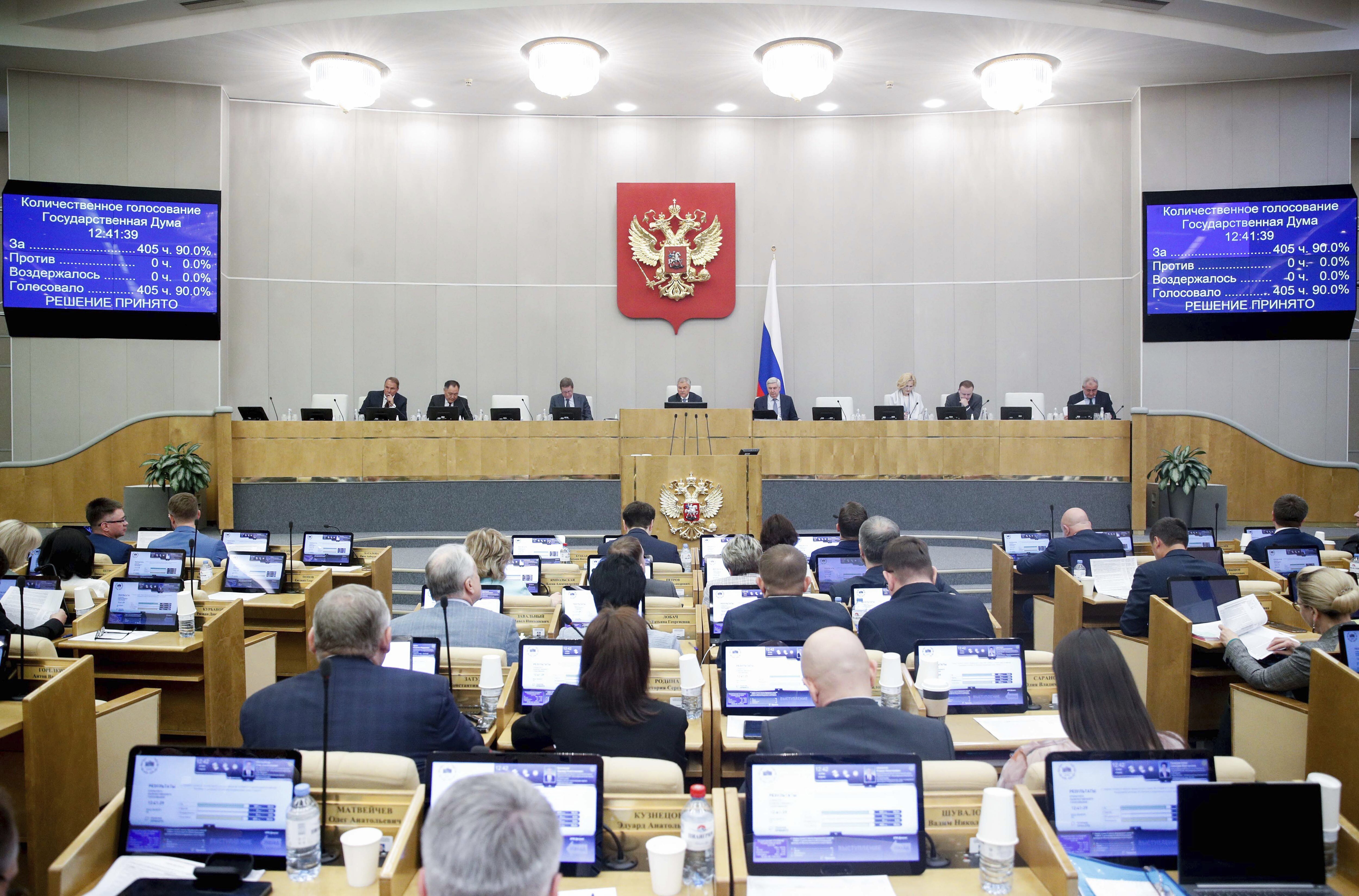 In this handout photo released by The State Duma, Russian lawmakers attend a session at the State Duma, the Lower House of the Russian Parliament in Moscow, Russia, Tuesday, May 16, 2023. Russian lawmakers on Tuesday voted unanimously to formally pull out of a Cold War-era security deal, more than eight years after Moscow halted its participation. (The State Duma, the Lower House of the Russian Parliament via AP)