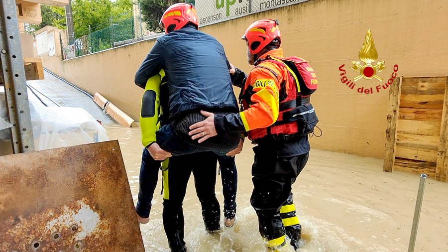 This photo provided by the Italian Firefighters shows firefighters rescuing a person from a flooded house in Riccione, in the northern Italian region of Emilia Romagna, Tuesday, May 16, 2023. Unusually heavy rains have caused major flooding in Emilia Romagna, where trains were stopped and schools were closed in many towns while people were asked to leave the ground floors of their homes and to avoid going out. (Vigili del Fuoco via AP)