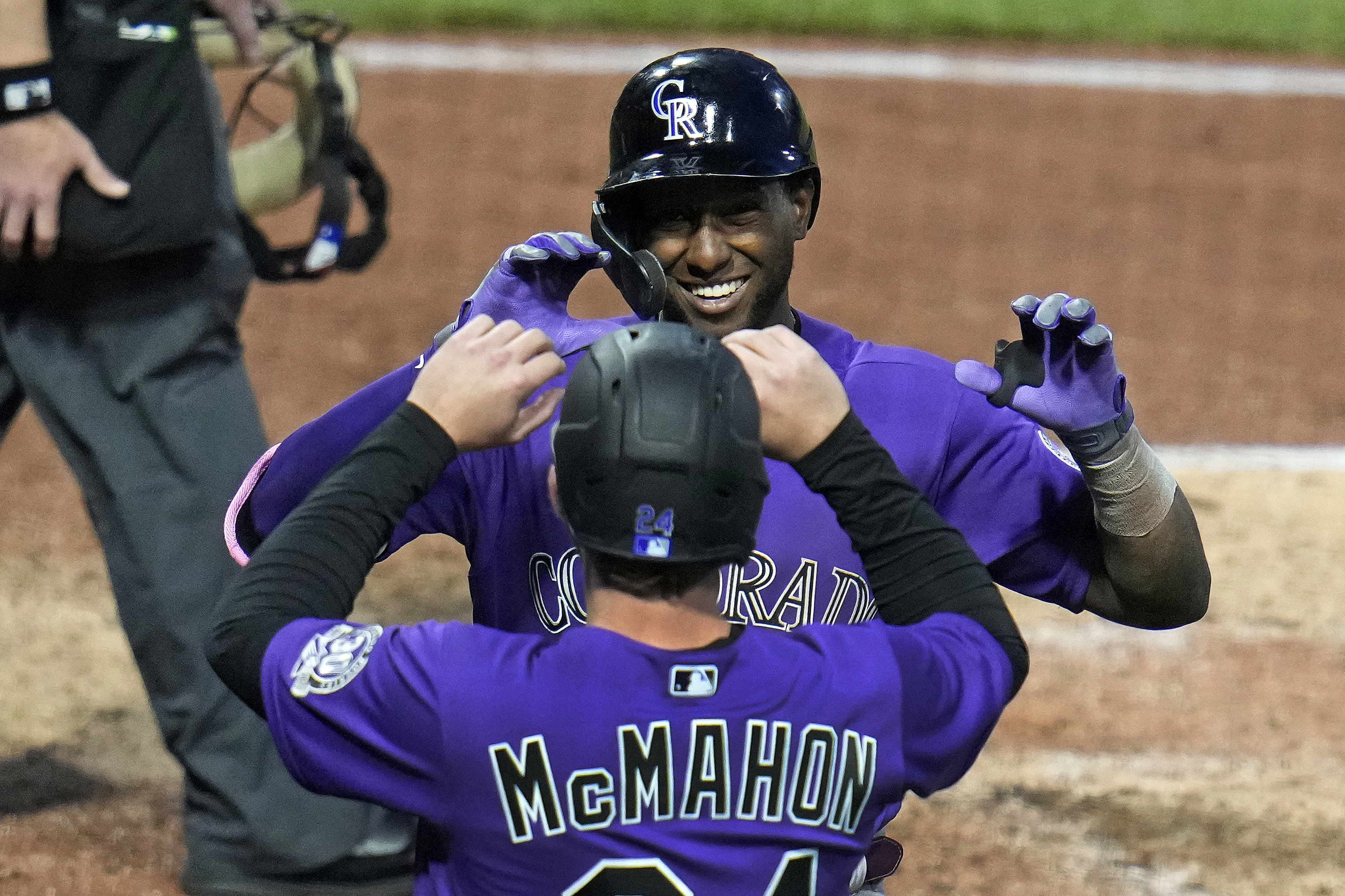 Colorado Rockies' Jurickson Profar, rear, celebrates with Ryan McMahon as he returns to the dugout