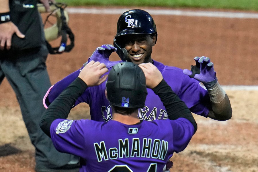 Colorado Rockies' Jurickson Profar, rear, celebrates with Ryan McMahon as he returns to the dugout