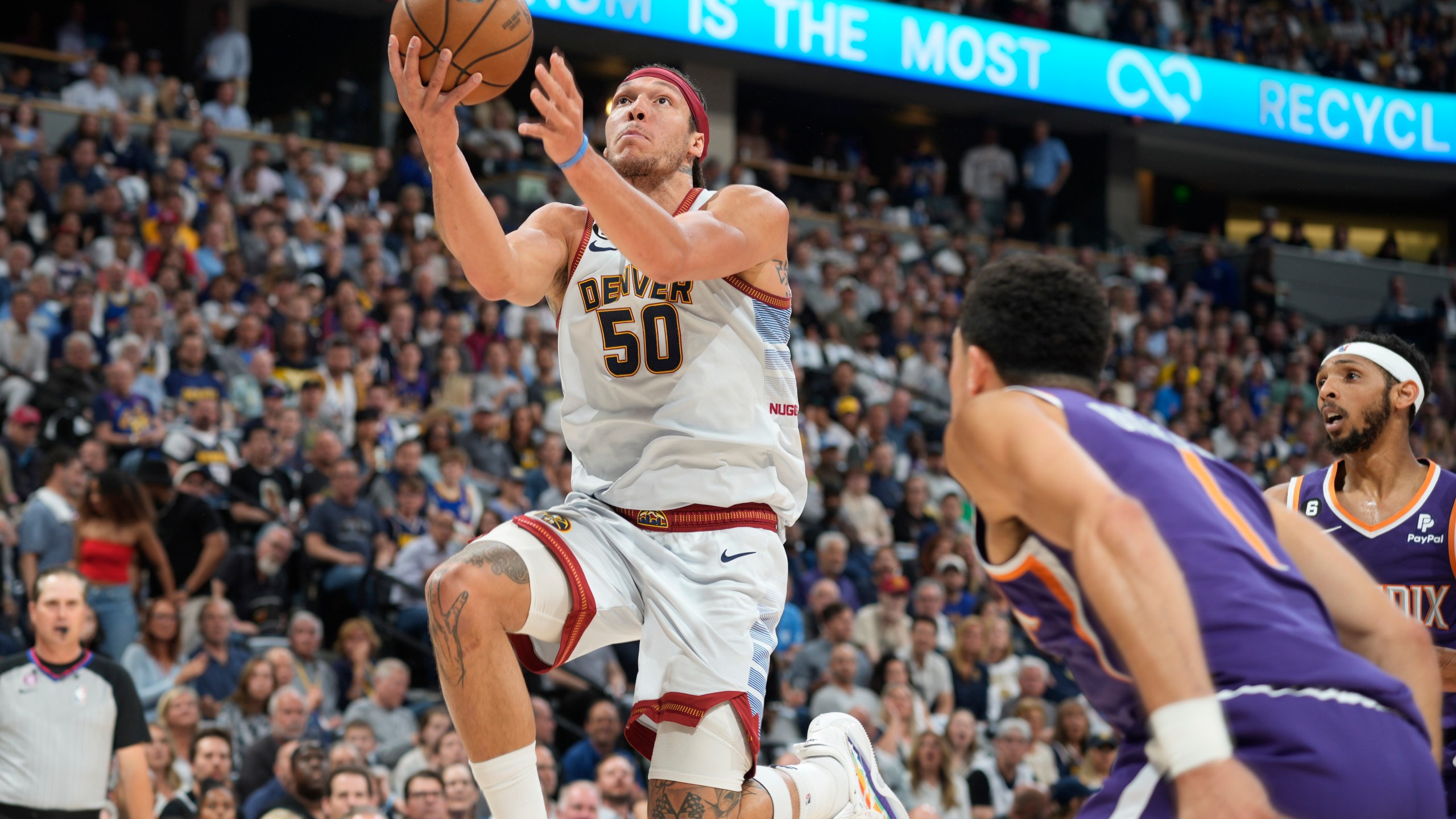 Denver Nuggets forward Aaron Gordon, left, drives the lane as Phoenix Suns guard Devin Booker defends