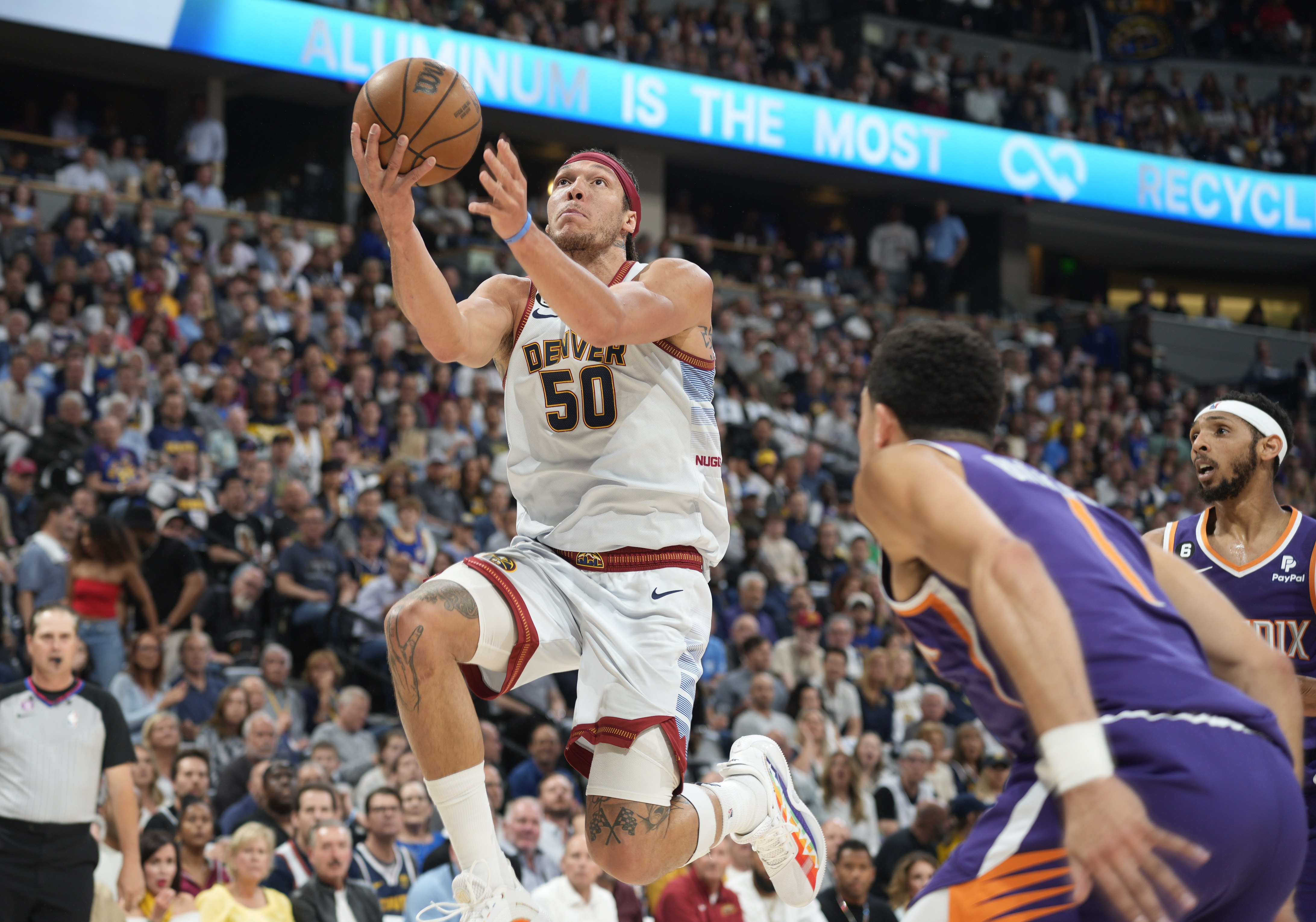 Denver Nuggets forward Aaron Gordon, left, drives the lane as Phoenix Suns guard Devin Booker defends