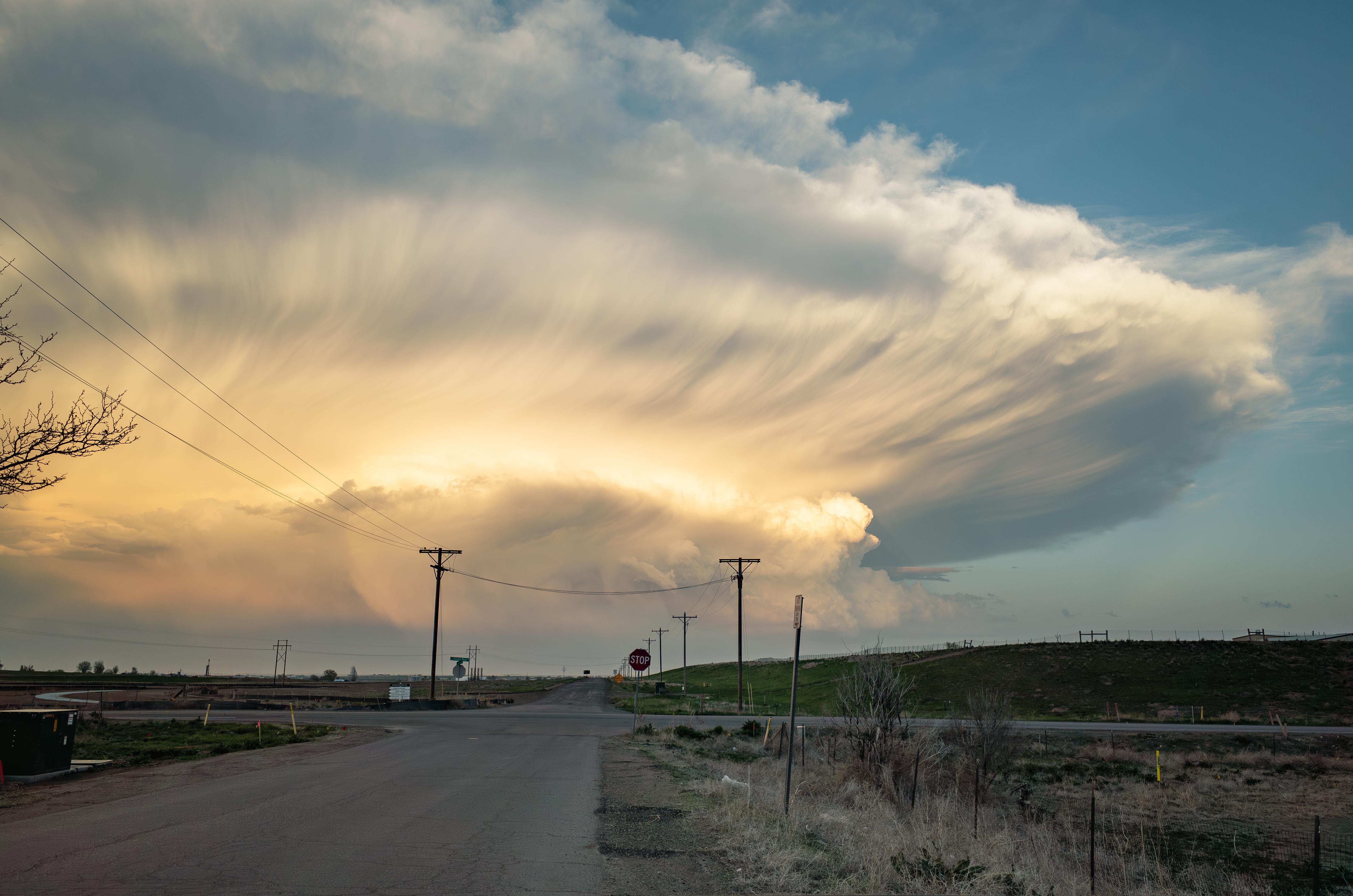 A cloud has pockets toward the bottom and expands across the horizon high in the sky.