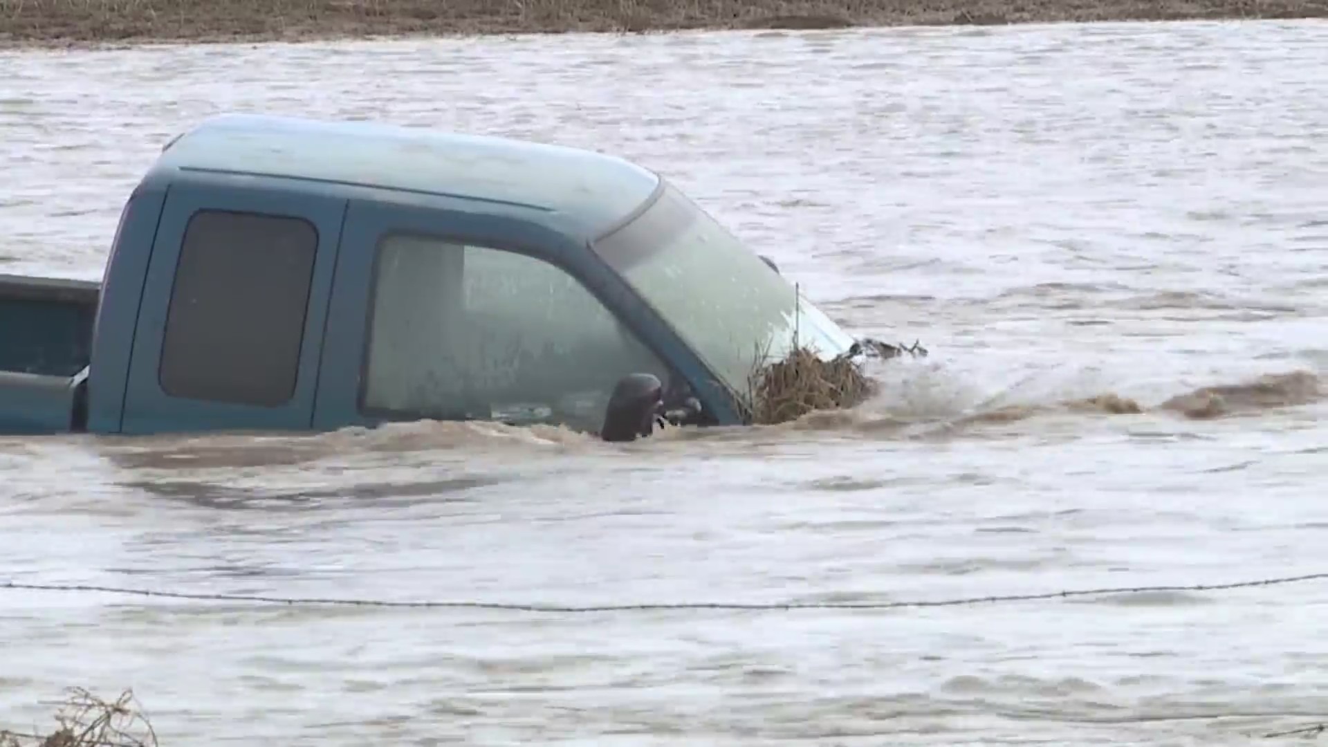 A pickup truck submerged in floodwaters