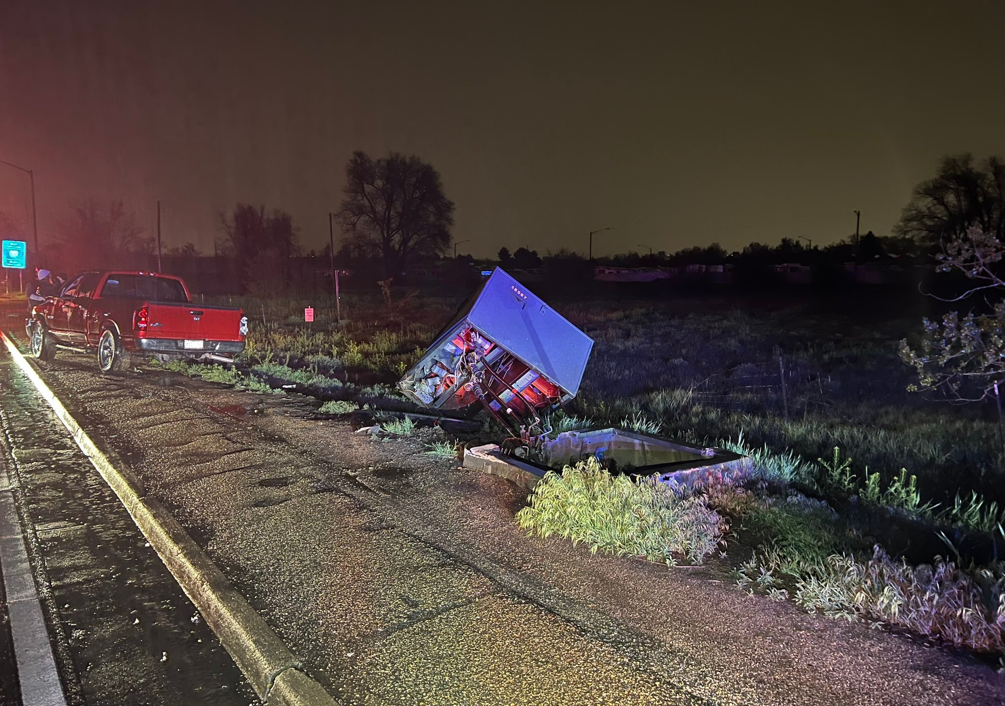 A power box is off its foundation on the side of the road