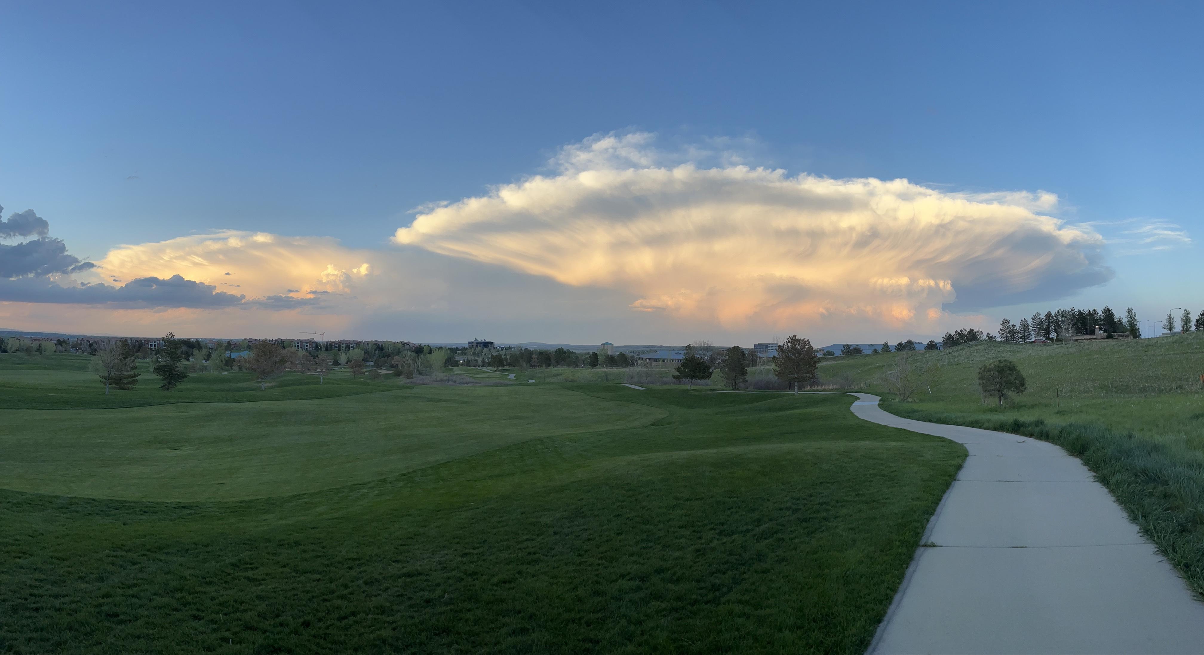 A cloud has pockets toward the bottom and expands across the horizon high in the sky.