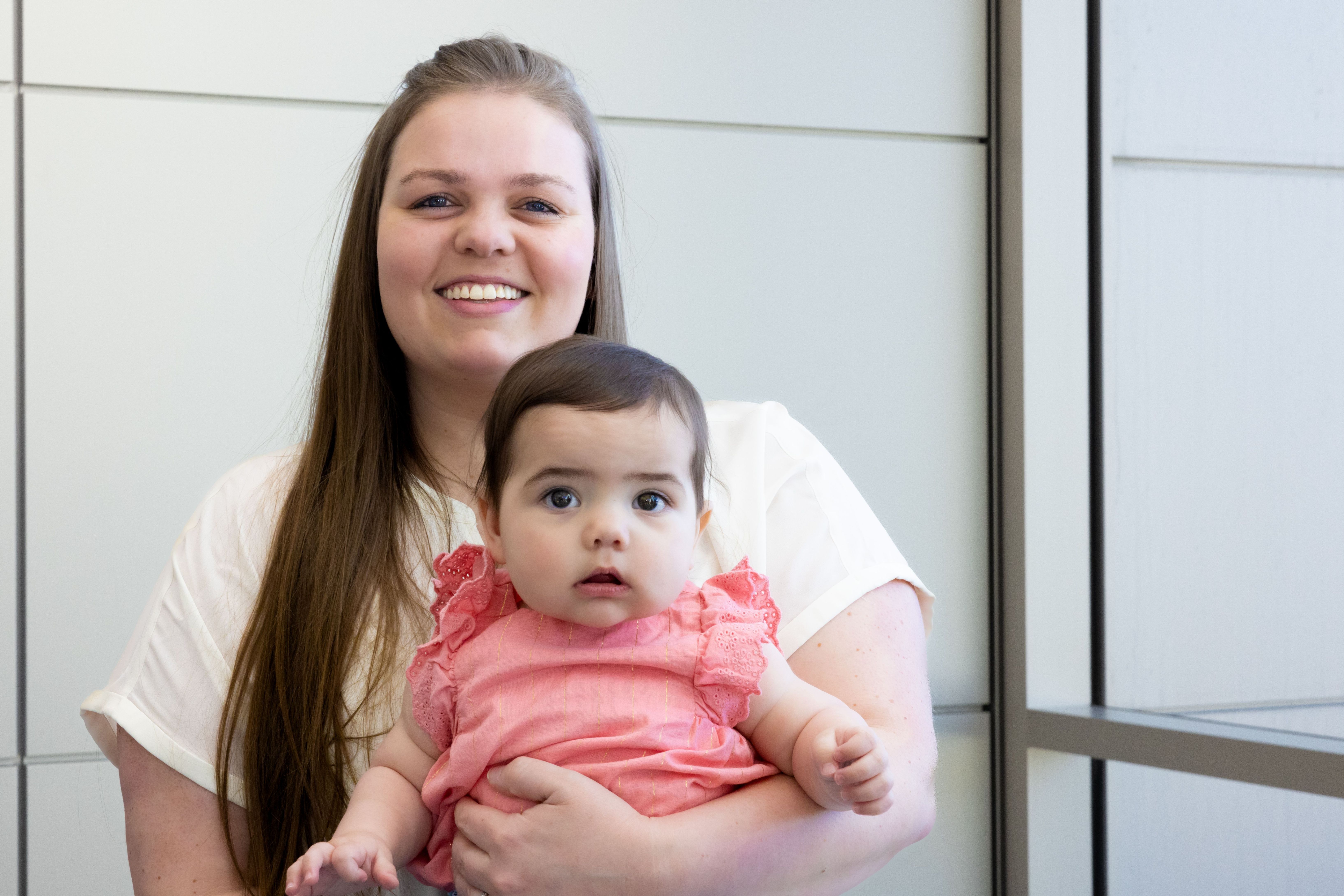 A nurse and her baby are smiling.