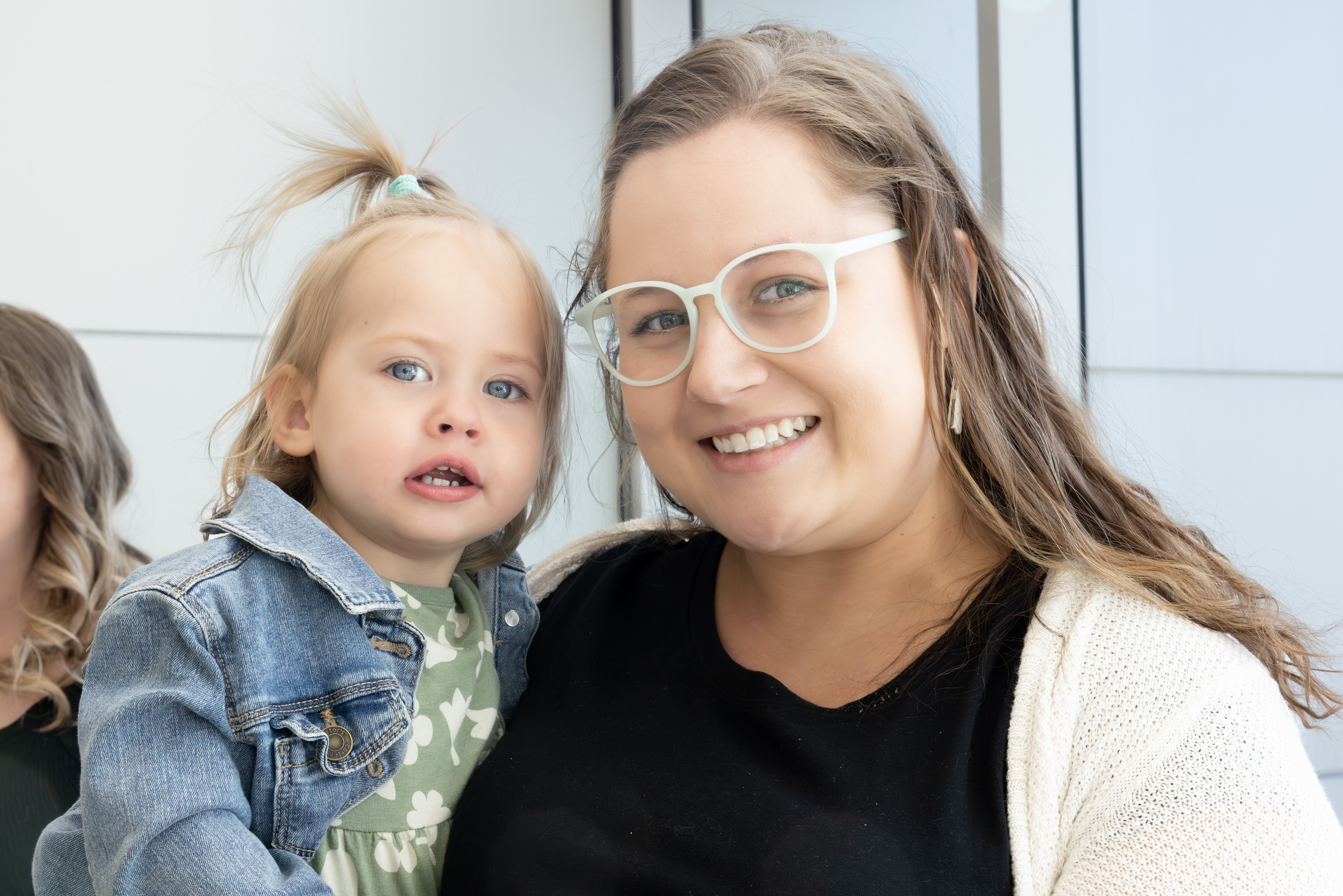 A nurse and her baby are smiling.