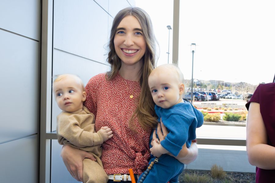 A nurse and her babies are smiling.