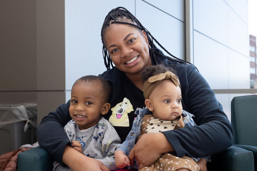 A nurse and her baby are smiling.