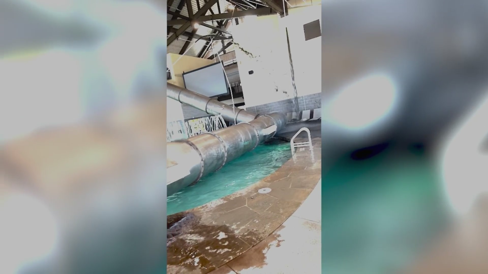 Screenshot of video showing a large HVAC pipe lying atop an indoor pool