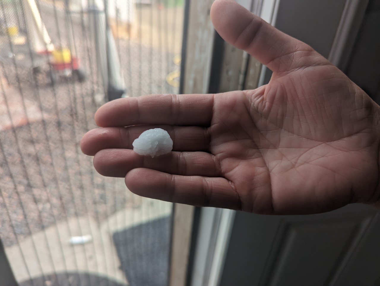 A piece of hail is held in hand