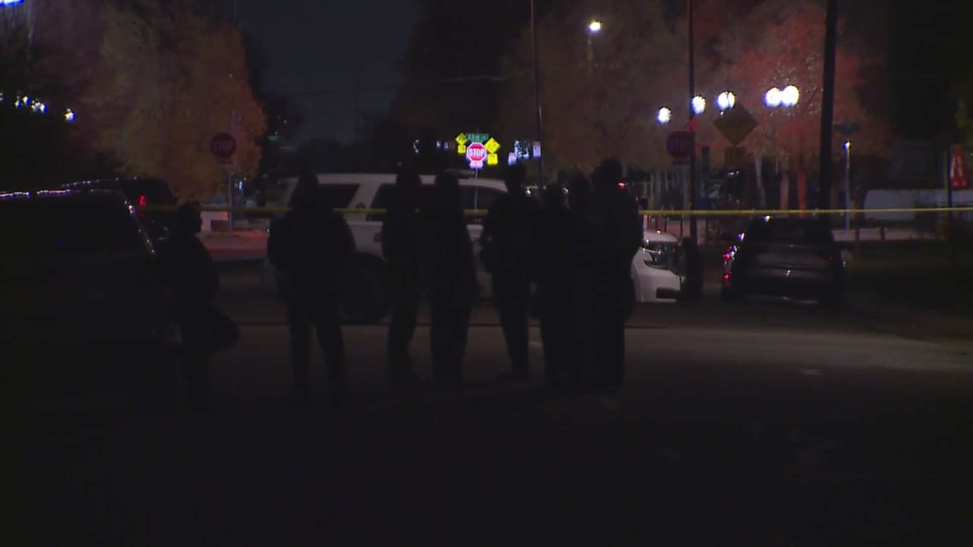 Police congregate outside a home on a street at night